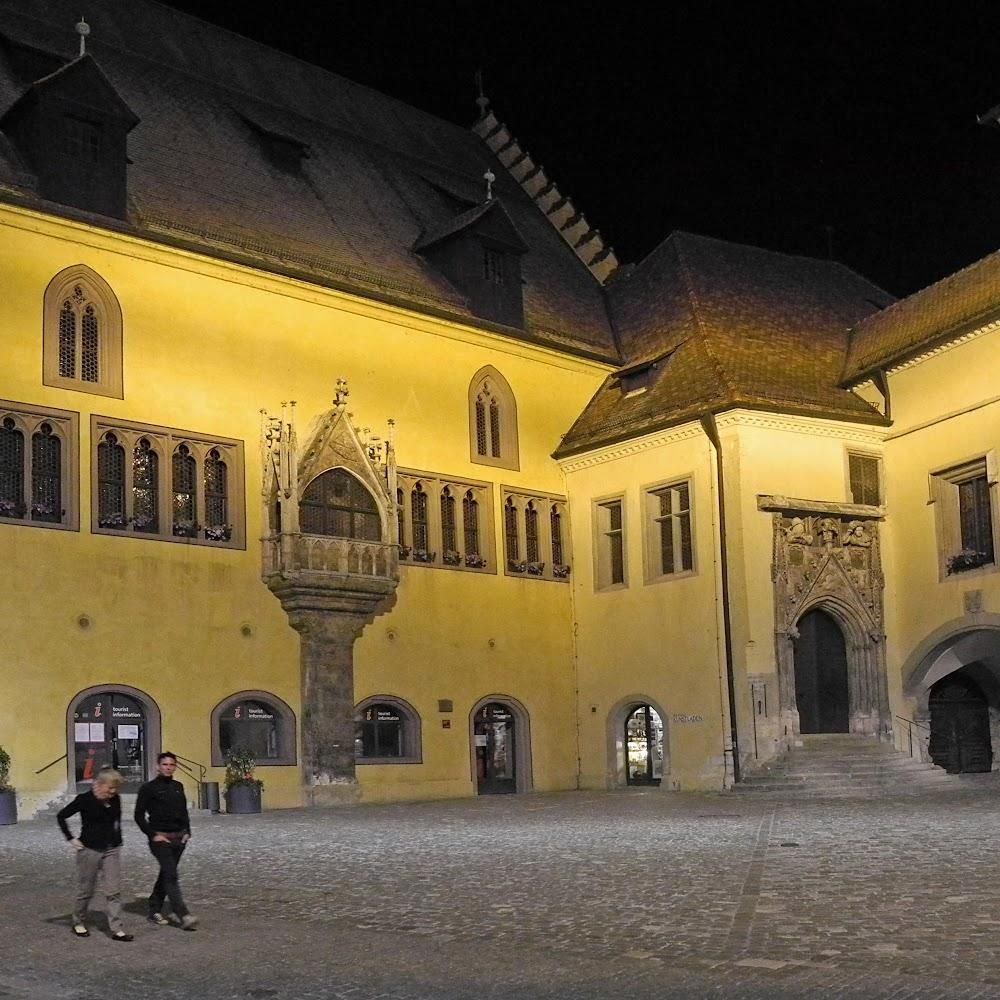 A yellow building with an arched entrance at night. The landmark is the Town Hall in Schaffhausen, Switzerland.